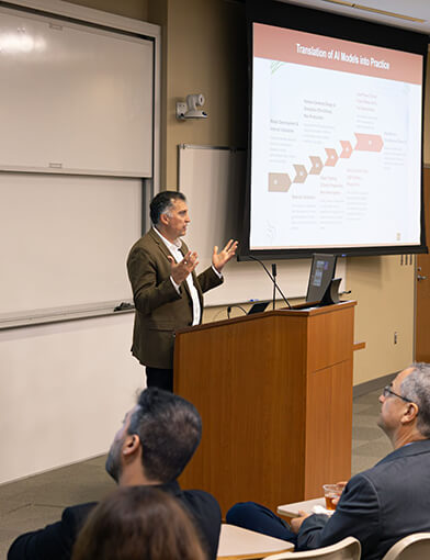 Majid Afshar, MD, MS, giving a speech at a podium.