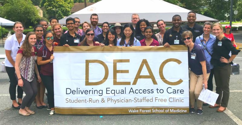 DEAC clinic students with their banner at an event.