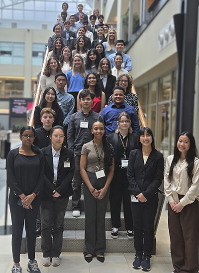 A group of REU interns dressed in business casual attire for a photo on a staircase.