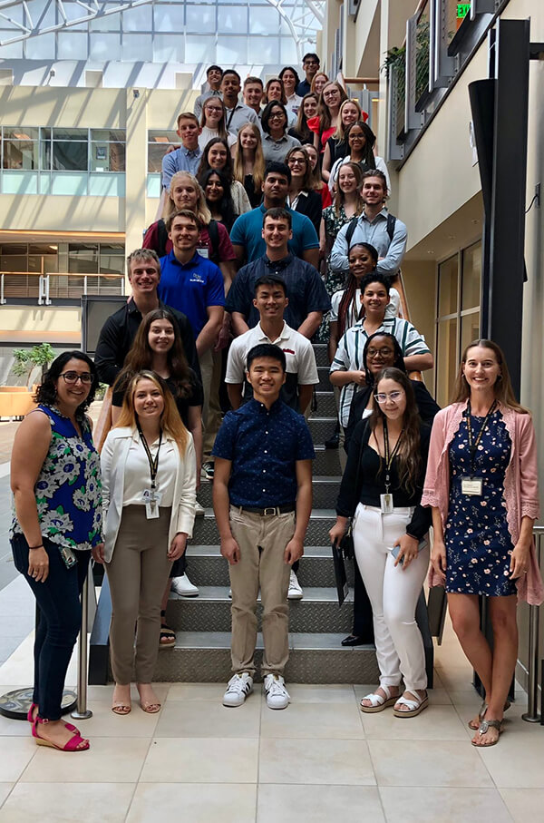 The 2022 undergraduates participating in the Department of Biomedical Engineering's summer research opportunities stand on the stairs.