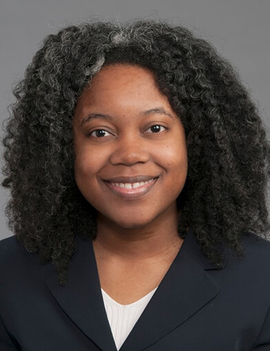 A woman wearing a black shirt smiling at the camera.