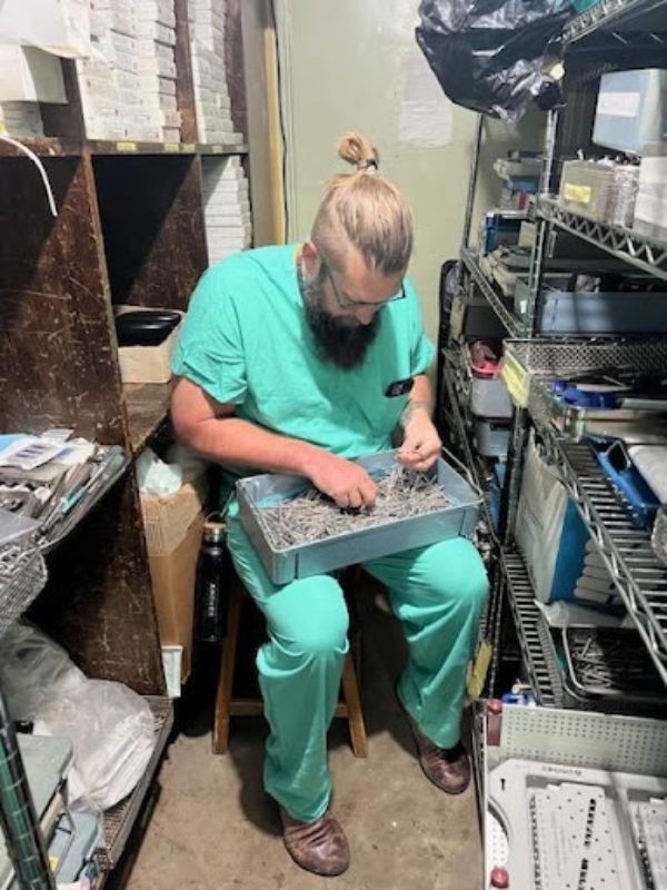 Wake Forest University School of Medicine International Medical Mission male nurse in scrubs working on a chair.