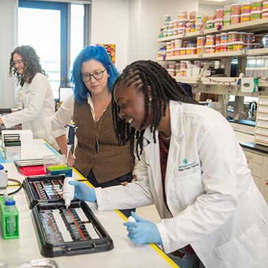 Three women working together on a science lab.