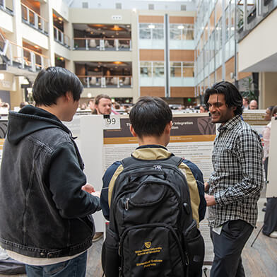A group of young men talking together in the lobby of a building.