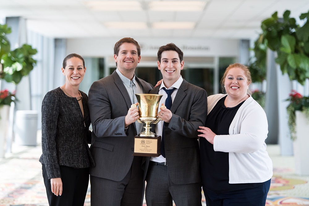Program director Dr. Stacey Wolfe and resident Jackie Renfrow celebrate with neurosurgery residents Mark Frenkel and James West as they display their trophy from winning the 2018 Congress of Neurological Surgeons SANS (Self-Assessment in Neurosurgery) Challenge