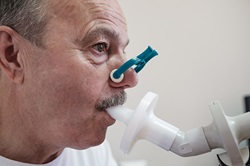 Senior hispanic man man testing breathing function by spirometry