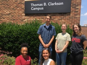 Group of 5 students standing in front of Thomas B. Clarkson Campus.