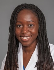 Young African American woman with long hair in braids wearing a white coat