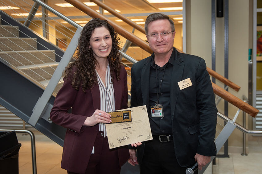 A student and professor taking a group photo at the Annual Research Day.