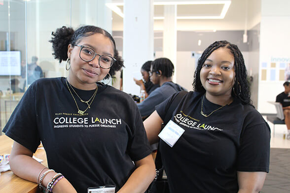 Two women in black t-shirts attending MEDucation Day 2024.