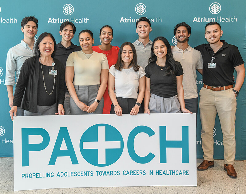 A group of people standing behind a banner that reads PATCH.