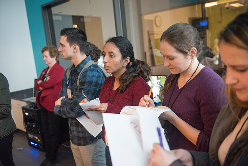A group of medical students listening and taking notes.