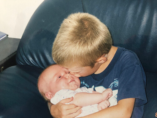 A child kissing a baby.