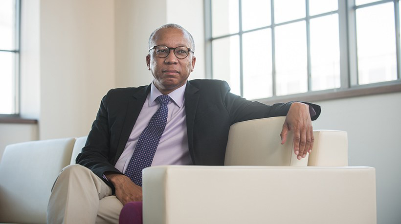 William Blackstock Jr., MD, sits on a white sofa