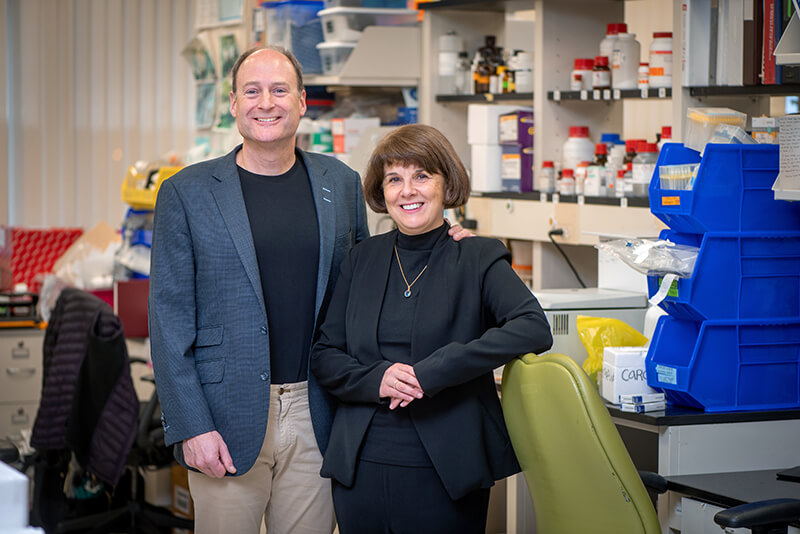 A man and a woman standing side by side and looking at the camera.