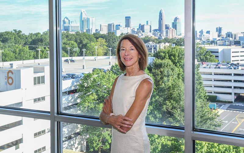 Dr. Michele Birch standing in front of a window with her arms crossed