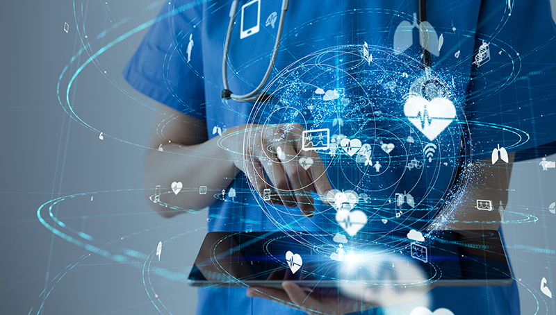 stock graphic of body of person in blue scrubs holding a tablet as symbols for health care swirl around above the tablet