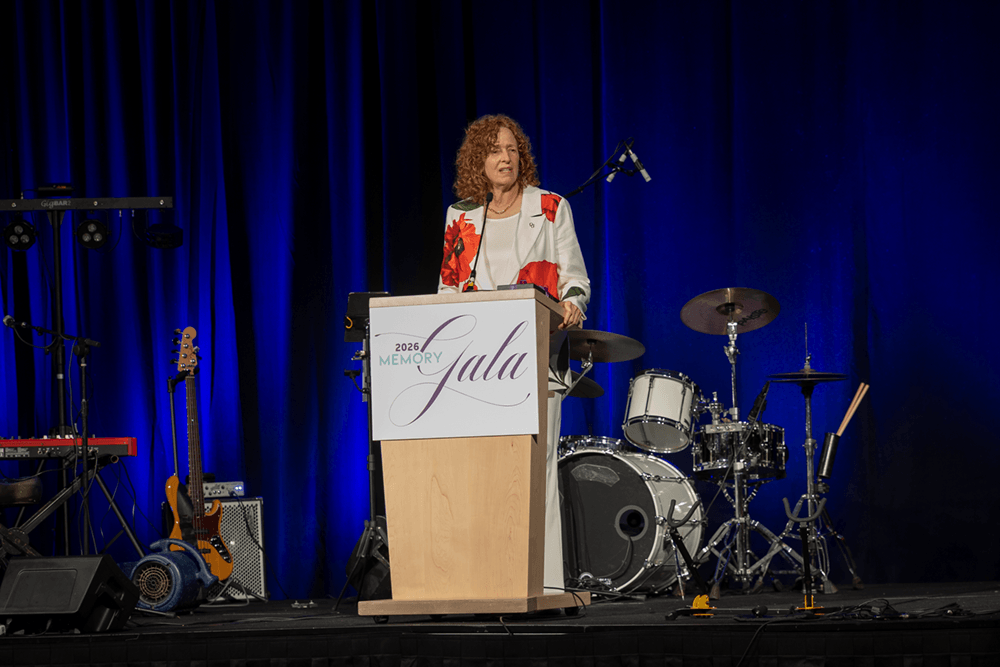 Laura Baker speaking at a podium.
