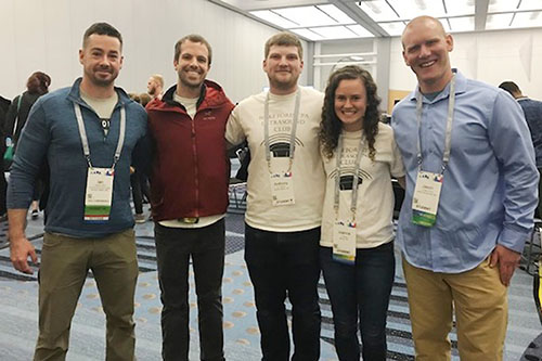 Small group of Wake PA students and faculty stand in hallway, close together and smiling, at 2019 annual AAPA conference in Denver, Colorado