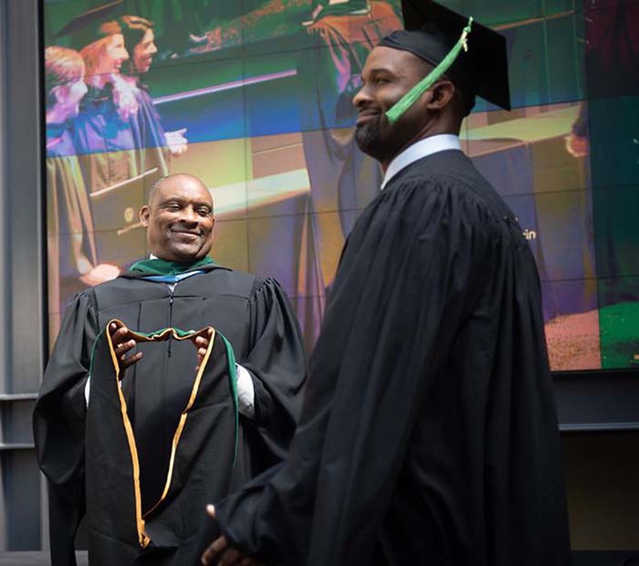 Wake PA Professor Robert Wooten hoods his son, Aaron Wooten, during Class of 2019 hooding ceremony 