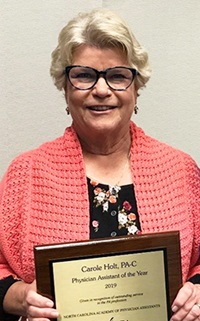 Carole Holt holds her plaque for being named the 2019 North Carolina Association of Physician Assistants PA of the Year