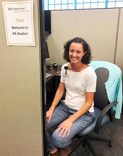 Tara Wommack smiles from her cubicle on her first day as PA Studies department project manager
