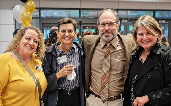 Four Wake PA alumni - three women and one man - stand together and smile at the Wake PA Program's 50th anniversary