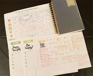 A planning calendar full of writing and color-coding lies open on a table