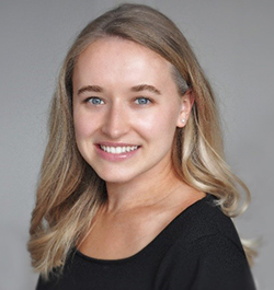 A white woman with long blonde hair smiles for a head shot