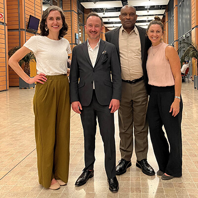 Two women and two men standing side-by-side smiling at the camera.