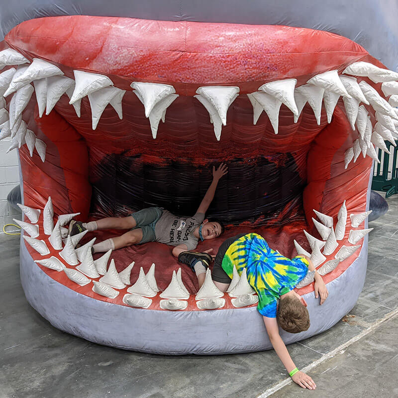 Two children playing on a display of a mouth.