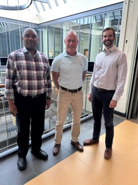 Dean Culler wearing a white polo and khakis, pictured here with Professor Robert Wooten and Program Director Brian Peacock who are wearing collared shirts and dress pants. 