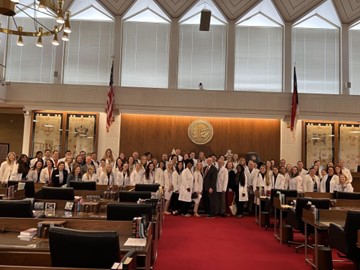 PA students, faculty and practicing PAs taking a group photo together in a government building.