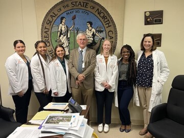 PA students, faculty and practicing PAs taking a group photo with a politician.
