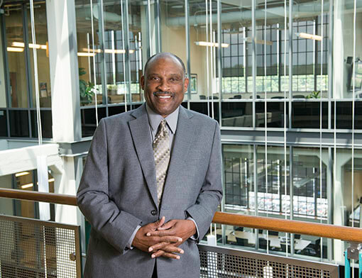 Robert Wooten posing for a photo while wearing a gray suit.