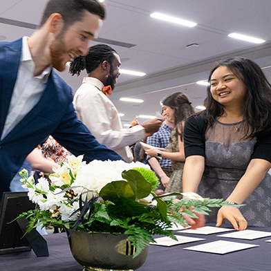 MD students rush to a draped table to pick up envelopes containing match results