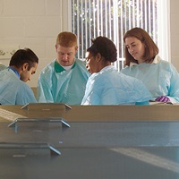 Students in lab wearing scrubs.