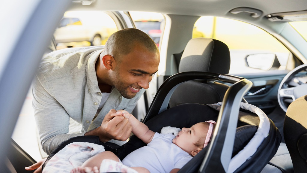 Dad putting baby in carseat