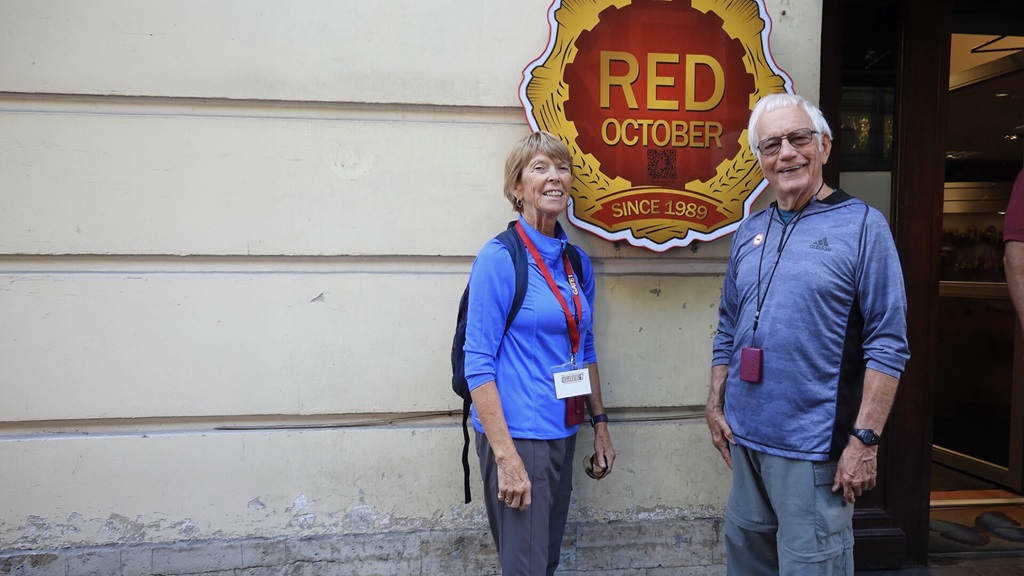Dr. Bill Lorentz standing with a woman wearing a bue shirt next to a sign that says, "Red October".