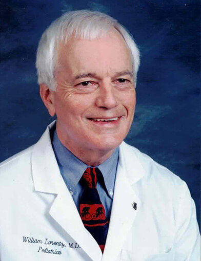 Dr. Bill Lorentz smiling and wearing a white lab coat.