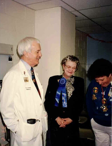 Dr. Bill Lorentz standing with an old man and woman.