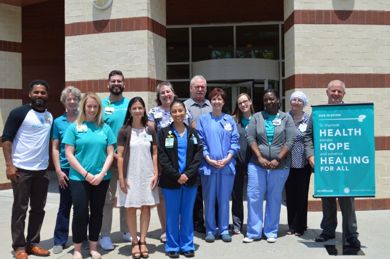 Behavioral Health teammates post in front of Behavioral Health Charlotte after suicide awareness press conference