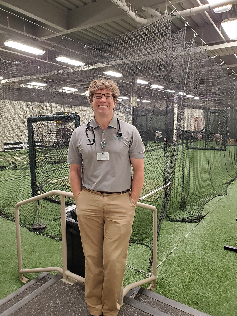 Dr. Eric Warren, sports medicine physician with Atrium Health Musculoskeletal Institute, stands in front of the batting cages at the Charlotte Knights stadium.