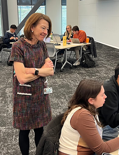 Dr. Michele Birch looking at students doing work in her class.