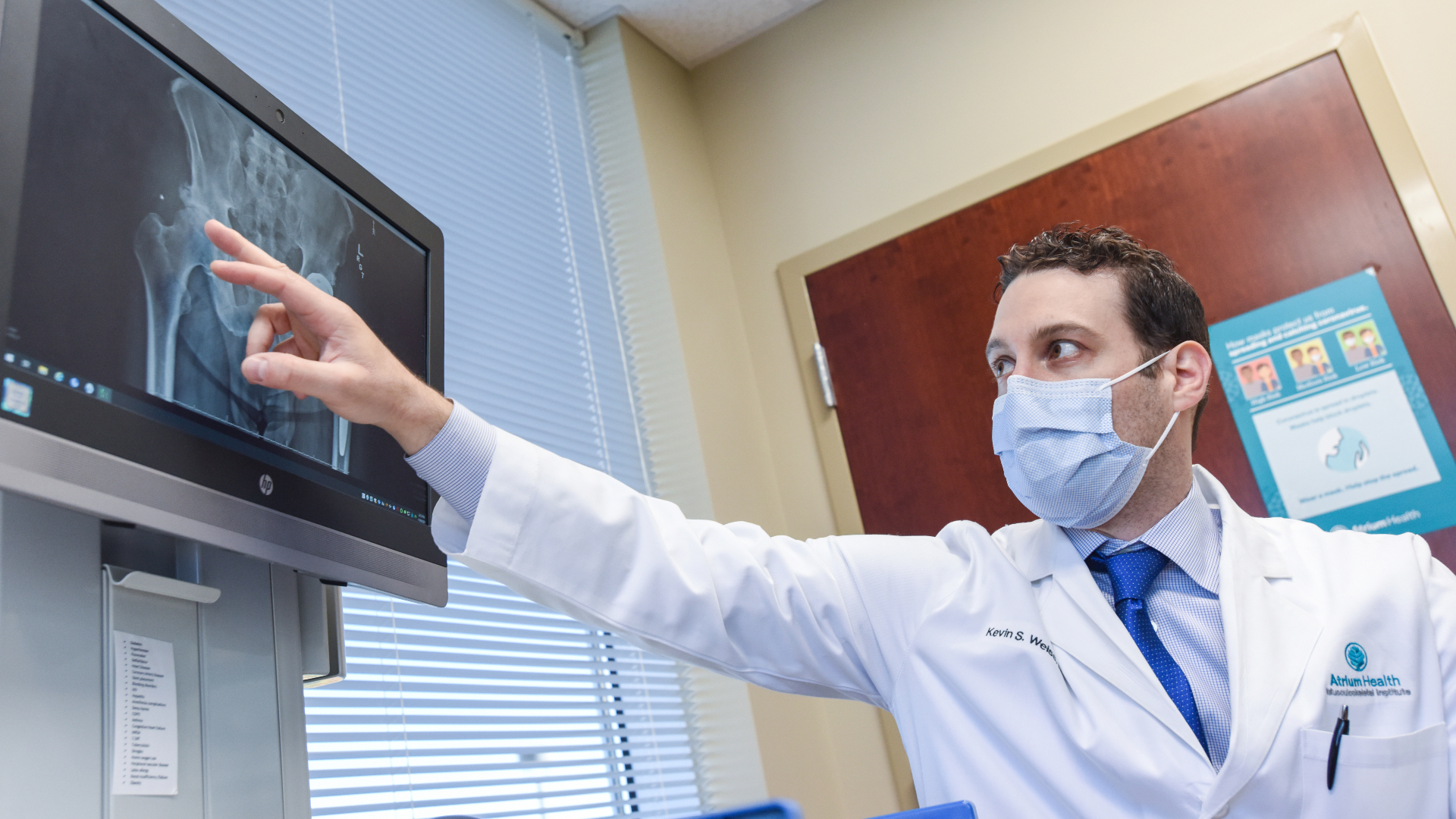 Dr. Kevin Weiss pointing to X-ray of hip needing replacement surgery 