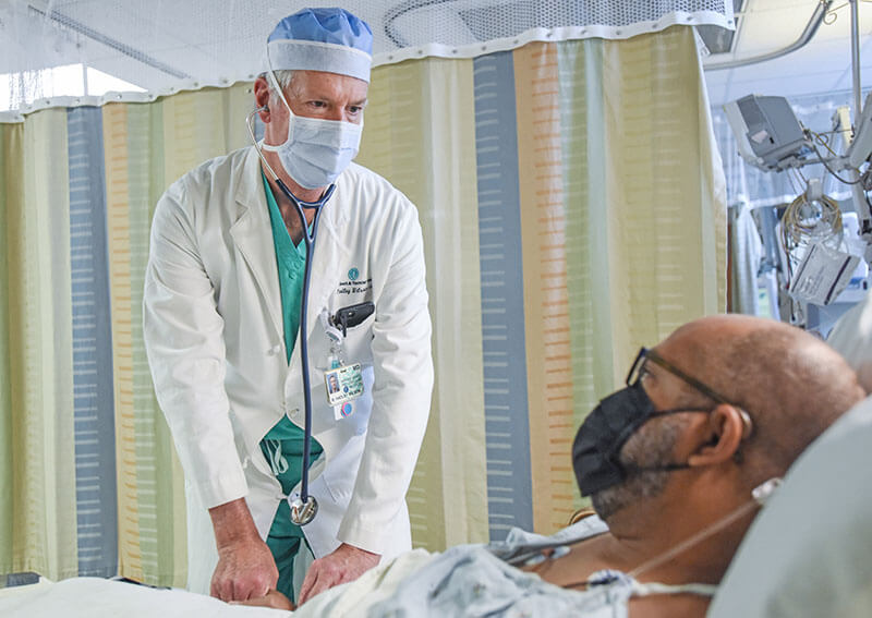 Dr. Hadley Wilson seeing a patient in his bed.