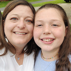 An older woman and a child smiling at the camera.