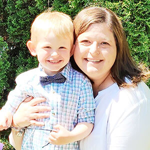 A parent and child smiling at the camera.