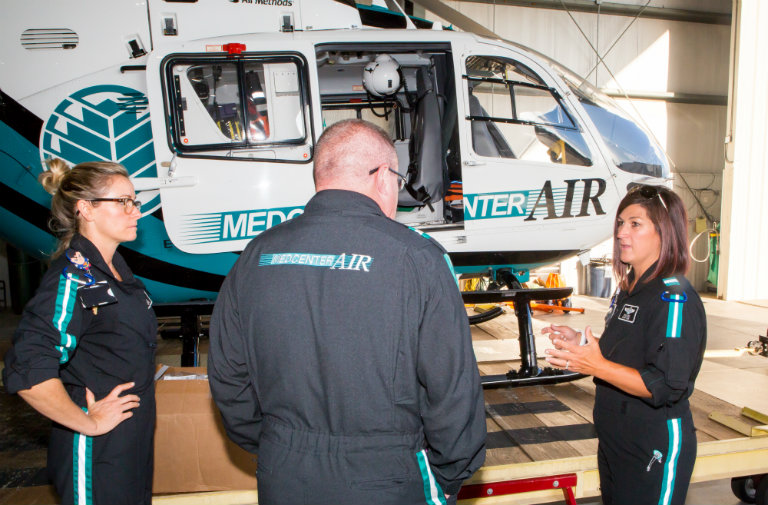Atrium Health's MedCenter Air nurses (from left) Liz Soriano, RN, Brian Huss, RN, and Erica Cook, RN, prepare a helicopter to be deployed ahead of Hurricane Florence. 