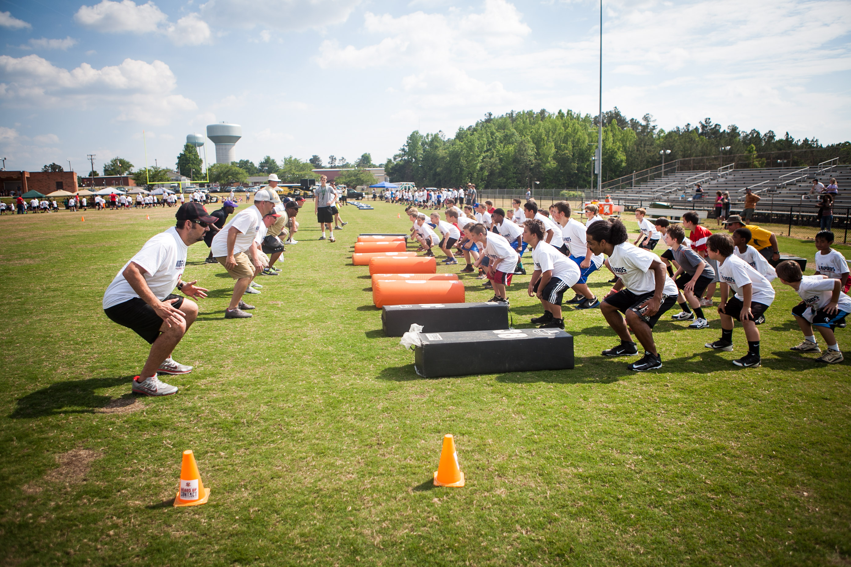 Youth football players running drills at practice